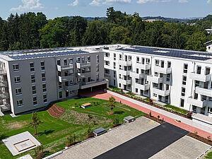 Wohnblock mit Wiese und Wald