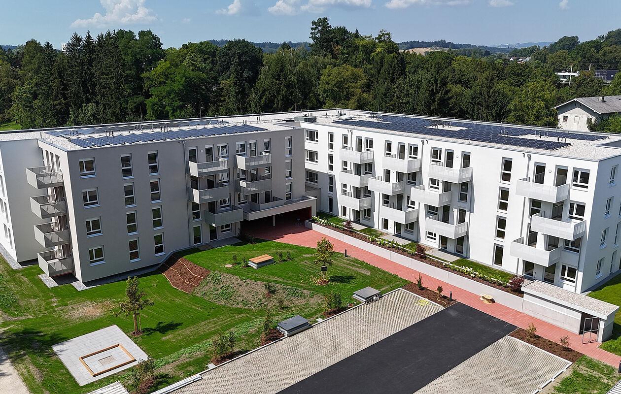 Wohnblock mit Wiese und Wald